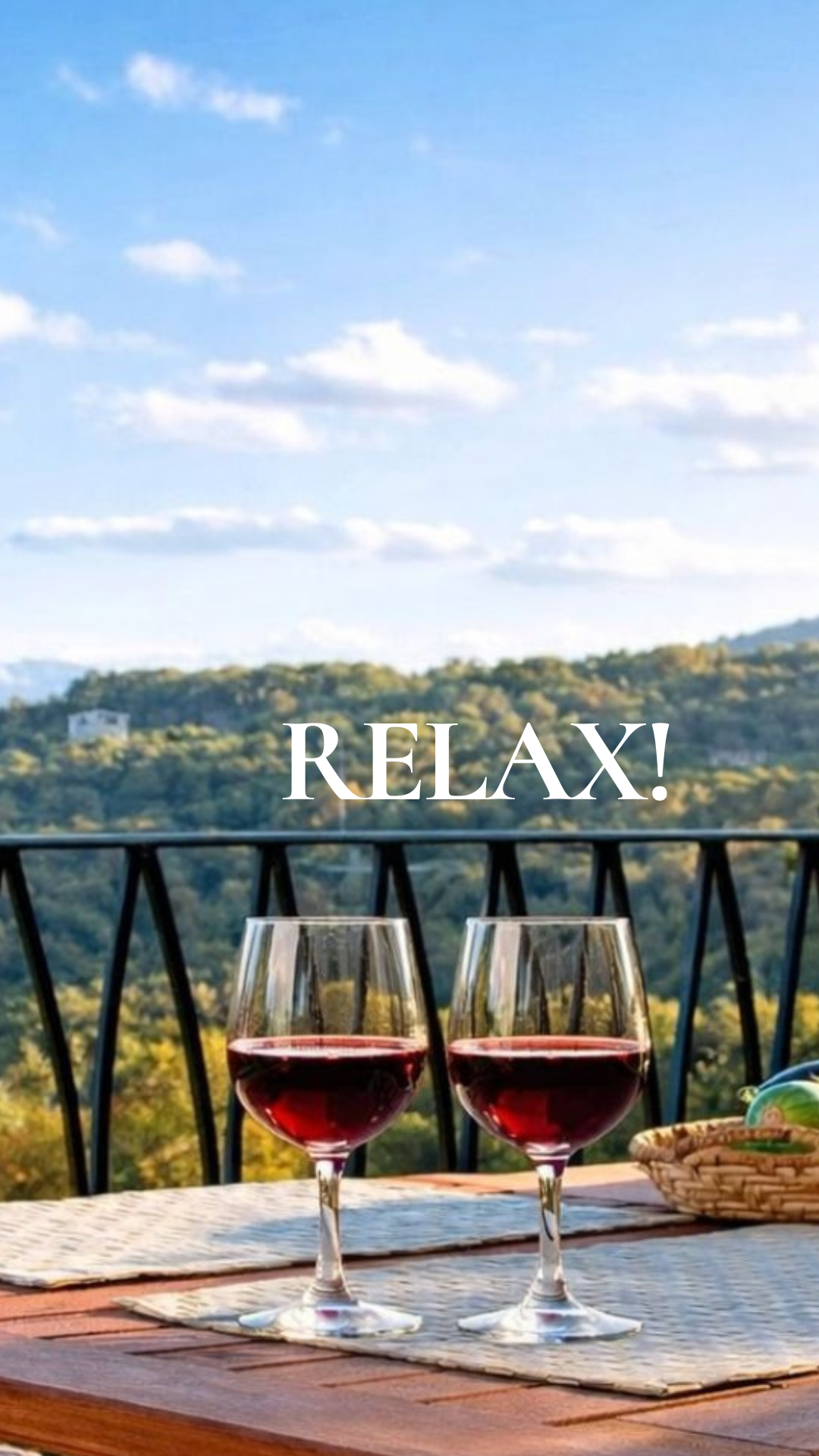 Due bicchieri di vino rosso su un tavolo con vista sulle colline della Sardegna, scritta RELAX!